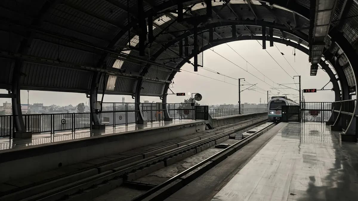 Metro train running on elevated track in Indian city with skyline in background